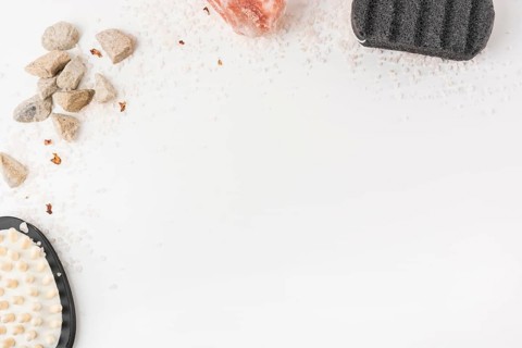 Overhead view salt massage brush pumice stone himalayan pink rock salt isolated white backdrop