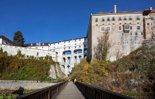 Pedestrian bridge over the Vltava with Mantle Bridge and Krumlov Castle
