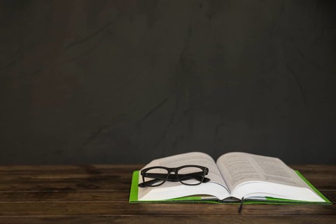 Opened book with glasses table