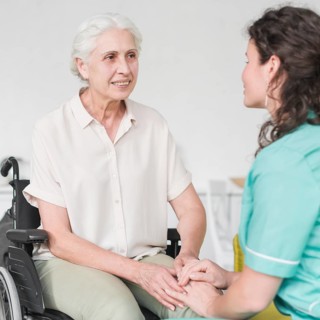 Happy disabled nurse sitting wheel chair looking caretaker