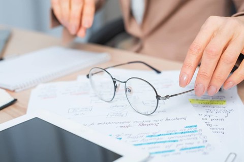 Close up woman s hand holding eyeglasses document