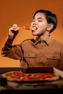 Medium shot kid eating pizza