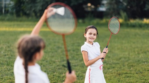 Two girls playing badminton park