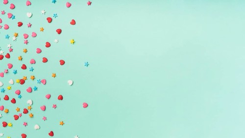 Stars hearts confetti turquoise background with copy space