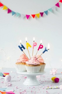 Front view birthday cupcakes with lit candles