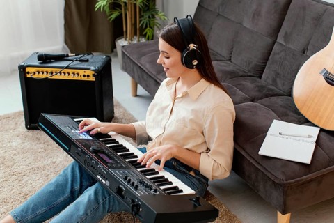 High angle female musician playing piano keyboard