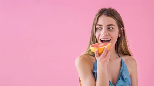 Girl bikini eating grapefruit