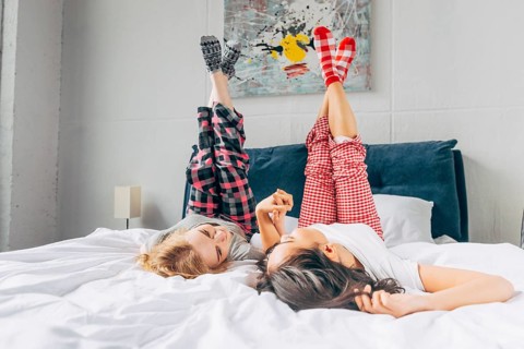 Women lying bed holding up crossing legs