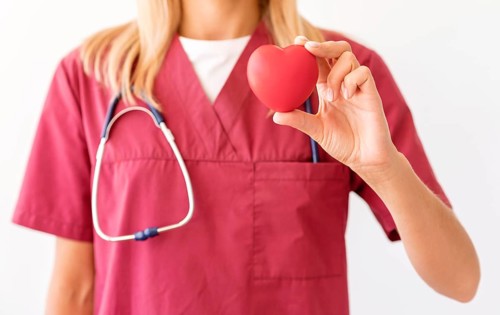 Front view female doctor holding heart shape