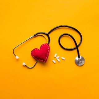 High angle view stethoscope stitched heart medicines yellow backdrop