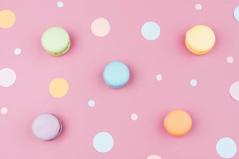 Arranged colorful macaroons with confetti top view