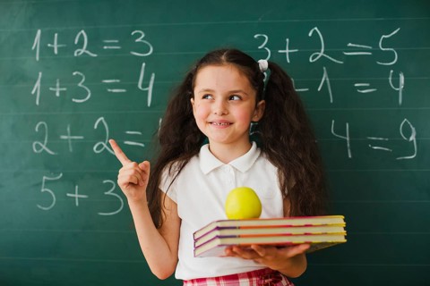 Schoolgirl pointing up blackboard