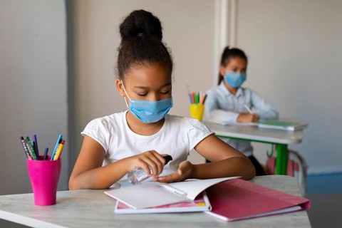 Little girl disinfecting her hands class