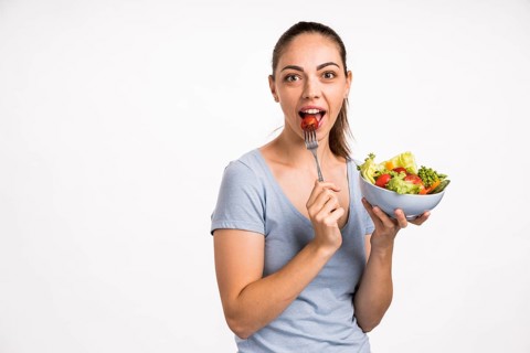 Woman eating tomato with fork
