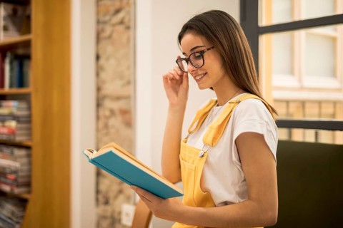 Attractive young woman reading book library