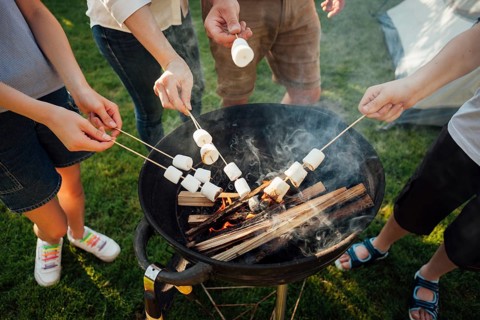 Elevated view hands roasting marshmallow barbecue fire