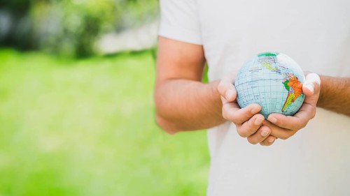 Mid section man holding globe hand