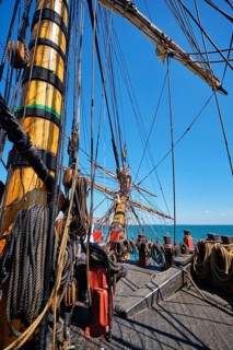 Deck with mast and ropes and bowspirit of wooden Age of sail sailing ship