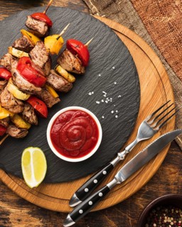 Top view delicious kebab slate with ketchup cutlery