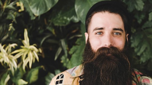 Panoramic view bearded young man looking camera