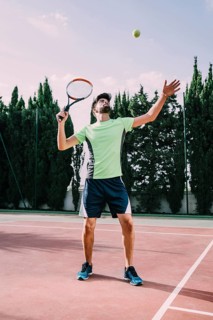 Tennis player green t shirt serving
