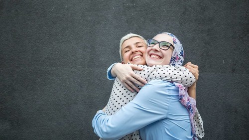 Friends sharing hug with black background