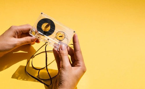 Person holding broken cassette tape with copy space