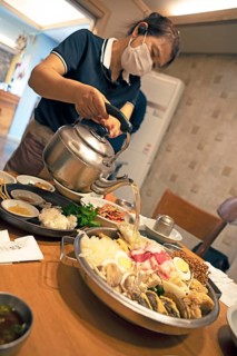 Korean woman pouring broth