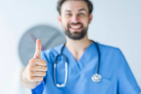 Blurred doctor showing thumb up gesture