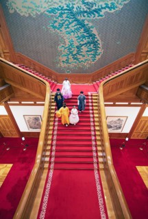 Visitors in traditional dress on the red staircase in the Blue House or Cheongwadae