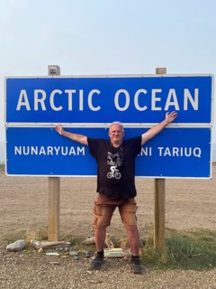 Tourist in front of sign Arctic Ocean