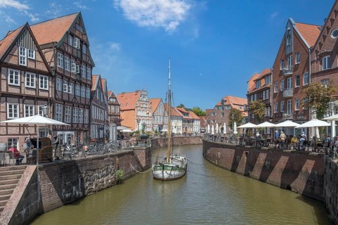 Historic merchant and warehouse houses at the Hanseatic harbour with the sailing ship Willi