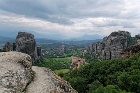 The monastery of Roussanou and behind it the monastery of Agios Nikolaos Anapafsas on sandstone rocks above the Pinios valley. The Greek Orthodox Meteora monasteries are built on sandstone cliffs abov...