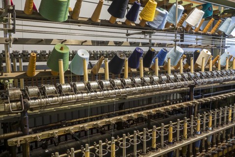 Colourful bobbins with yarns on twisting frame in cotton mill