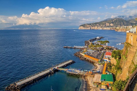Bathing terraces by the sea with town and Vesuvius