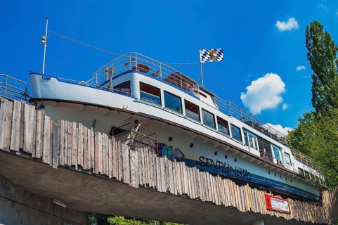 Converted ship on railway bridge as restaurant and bar