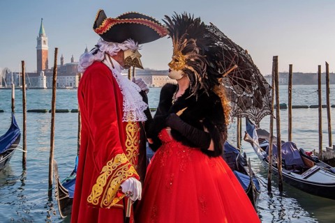 Carnival masks on the waterfront with San Giorgio Island at the time of Carnival