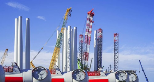 Wind turbine nacelles with rotor hubs and tower sections for offshore SeaMade wind farm at REBO heavy load terminal in Ostend port