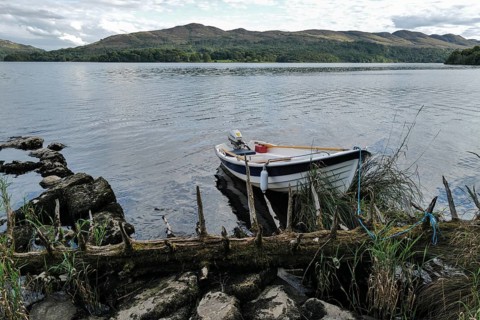 A motor boat tied up on the shores of Lough Gill at evening time. Sligo