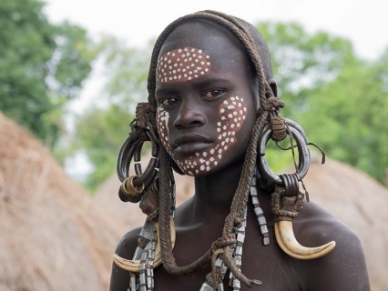Girl of the Mursi tribe with headdress and face painting
