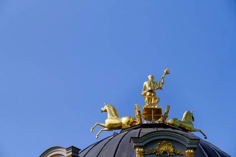 Golden quadriga guided by a torch-bearing Apollo