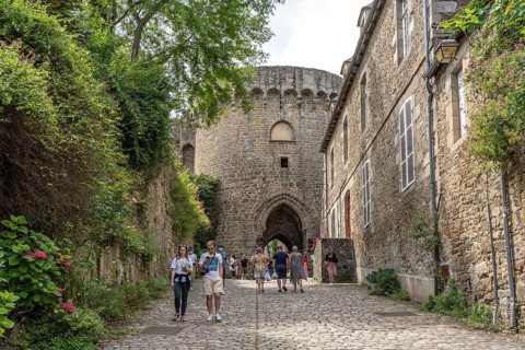 Alley with cobblestones and city wall in the historic old town of Dinan