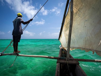 Local man steering outrigger boat