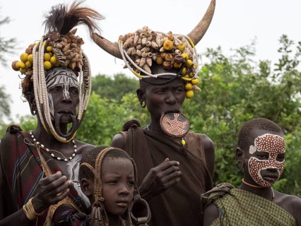 Women and children of the Mursi tribe with headdress and lip plate