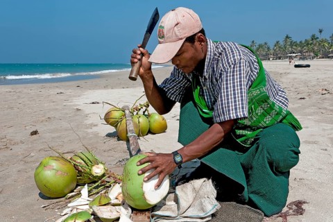 Man opening coconuts on the beach