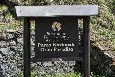 Wooden welcoming board with logo of the Gran Paradiso National Park in the Graian Alps