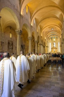 Priests in solemn vestments enter the Cathedral di San Cerbone for Mass on Holy Thursday
