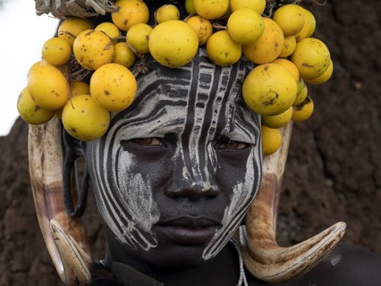 Woman of the Mursi tribe with headdress and face painting