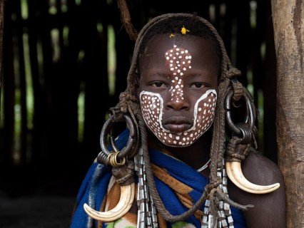 Boy of the Mursi tribe with headdress and face painting