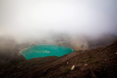 Fog over crater with turquoise crater lake